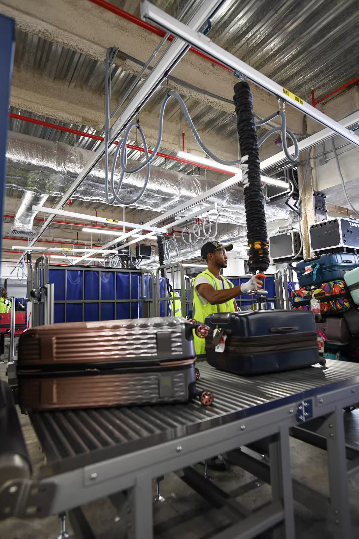 Elevador por vacío manipulando maletas en aeropuerto